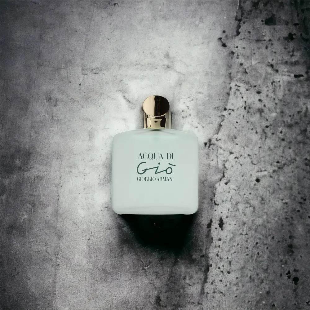 Acqua Di Gio Damenparfum Flakon mit goldenem Verschluss auf grauem Hintergrund