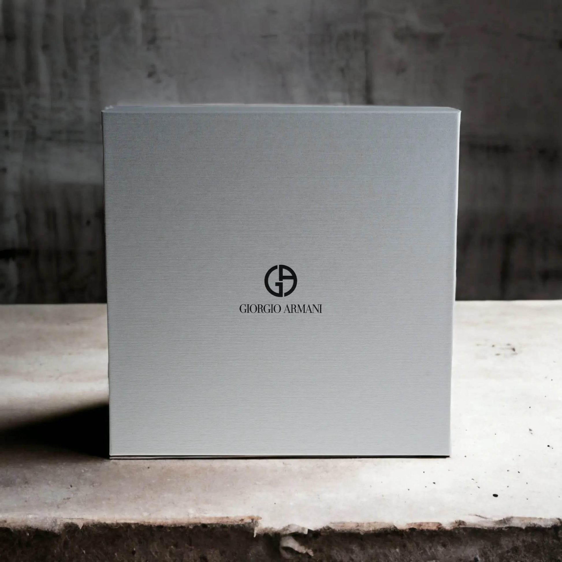 Elegante graue Geschenkbox mit Giorgio Armani Logo, minimalistisch auf hellem Untergrund