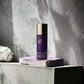 Lila Mugler Alien Deodorant Spray mit goldener Kappe auf grauem Stein, luxuriöses Design