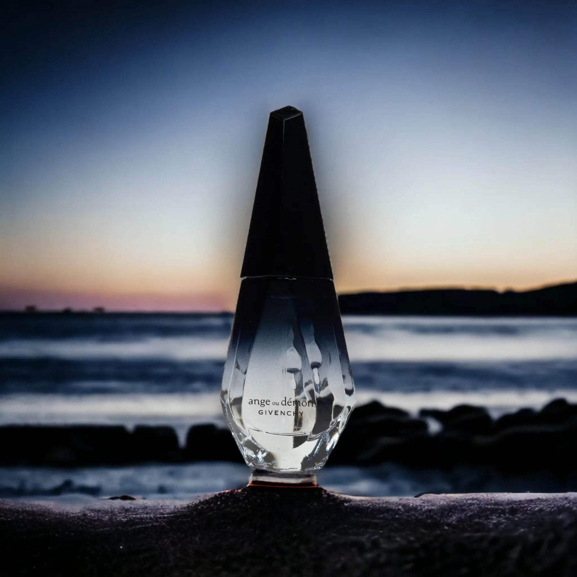 Luxuriöser Parfumflakon vor Meer und Sonnenuntergang, stilvolles Designer-Flakon