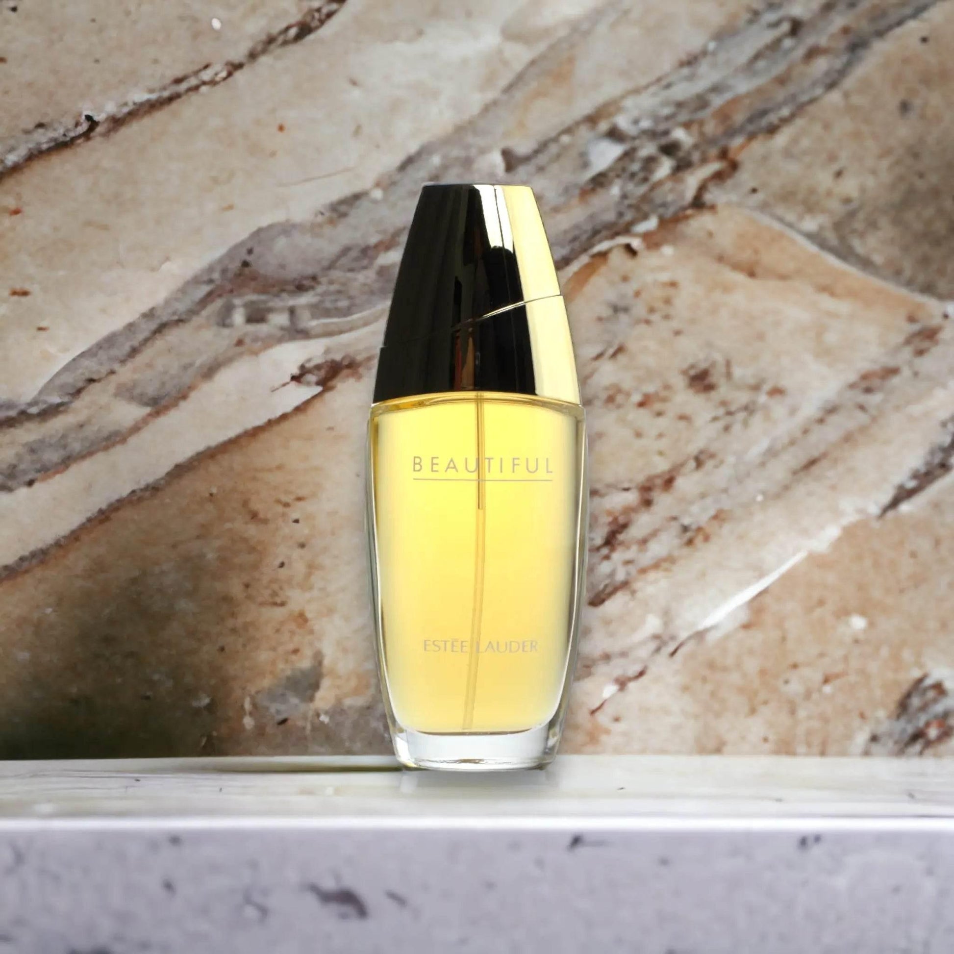 Eleganter Flakon Eau de Parfum mit goldfarbenem Verschluss auf Marmoroberfläche, Luxusduft
