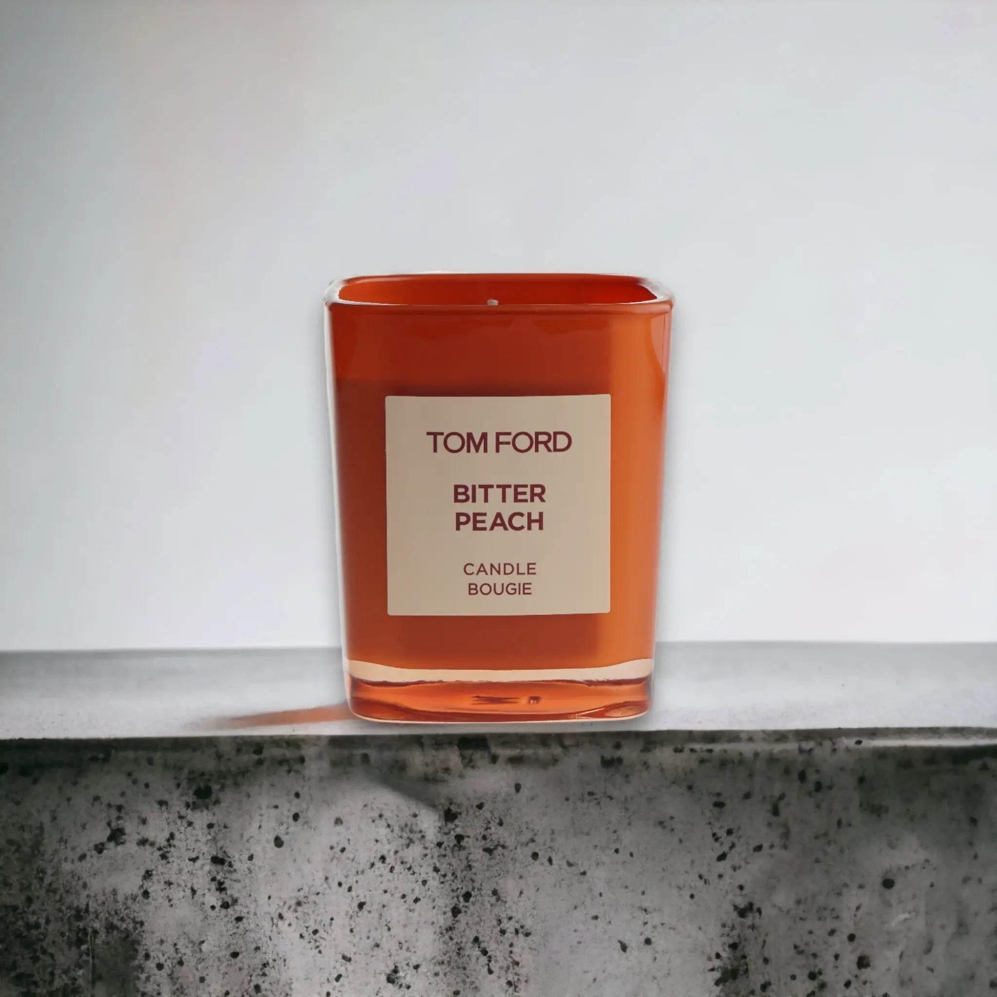 Orange Duftkerze Tom Ford Bitter Peach auf Betonoberfläche, edles Design, Luxuskerze