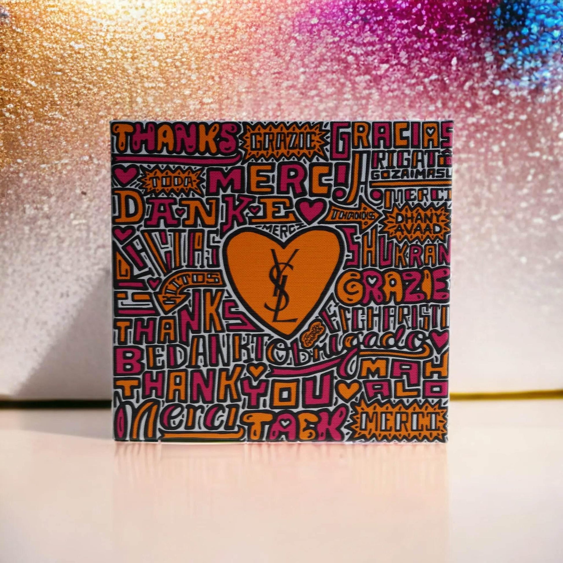 YSL Parfum Geschenkset Verpackung mit buntem Schriftzug und Herzmotiv vor buntem Hintergrund