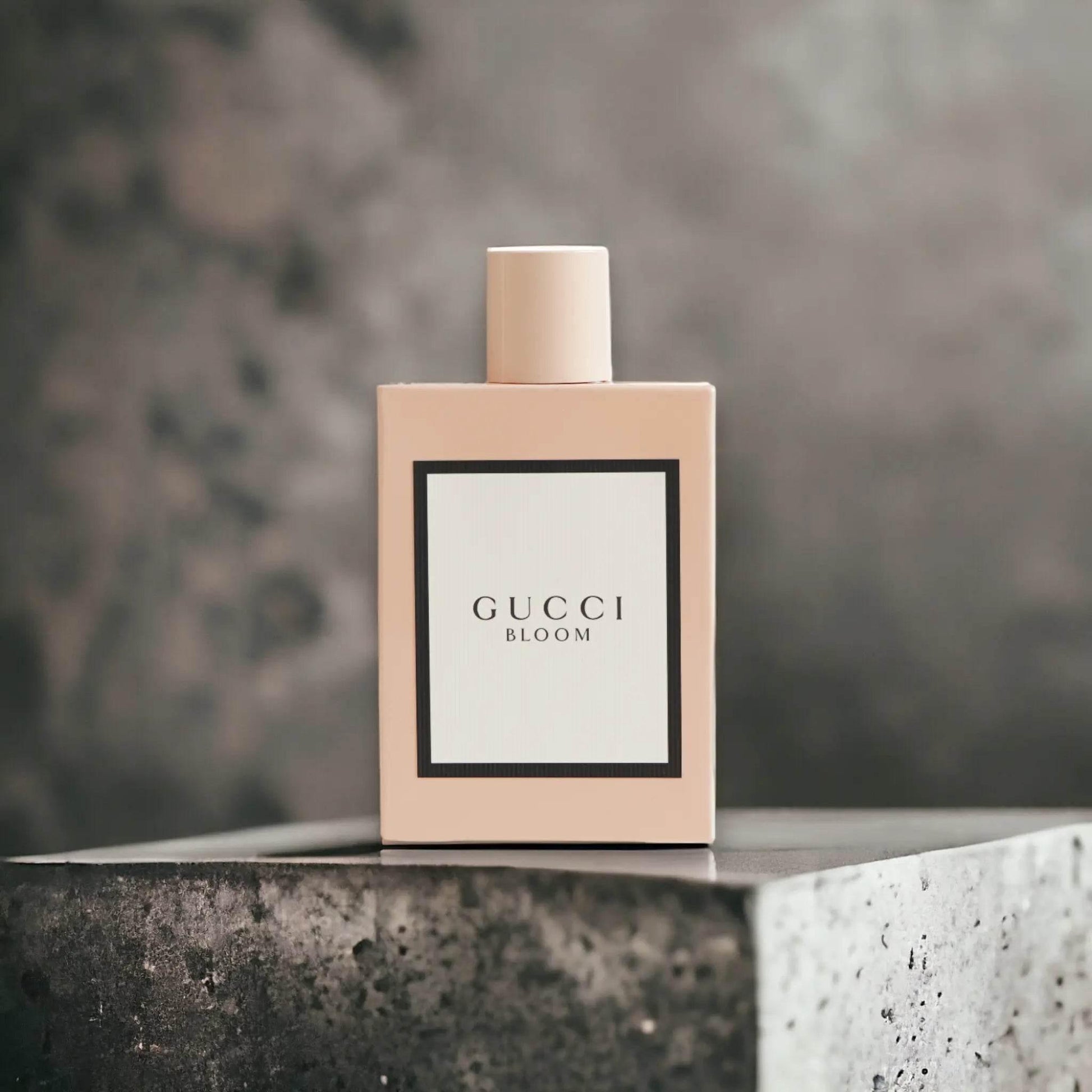 Beiger Parfümflakon Gucci Bloom auf steinfarbenem Hintergrund, Luxusduft, Nischenparfum
