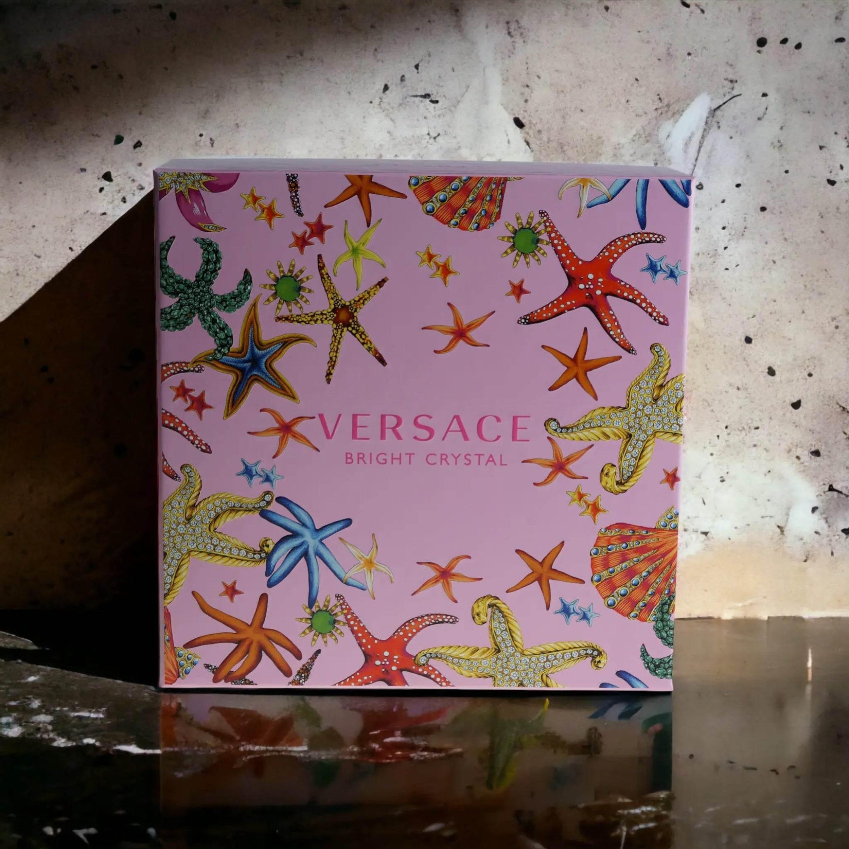 Versace Bright Crystal Parfum Geschenkbox mit Seestern-Muster auf rosa Hintergrund