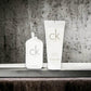 CK One Duftset mit Eau de Toilette und Body Wash vor Betonhintergrund, moderne Parfums