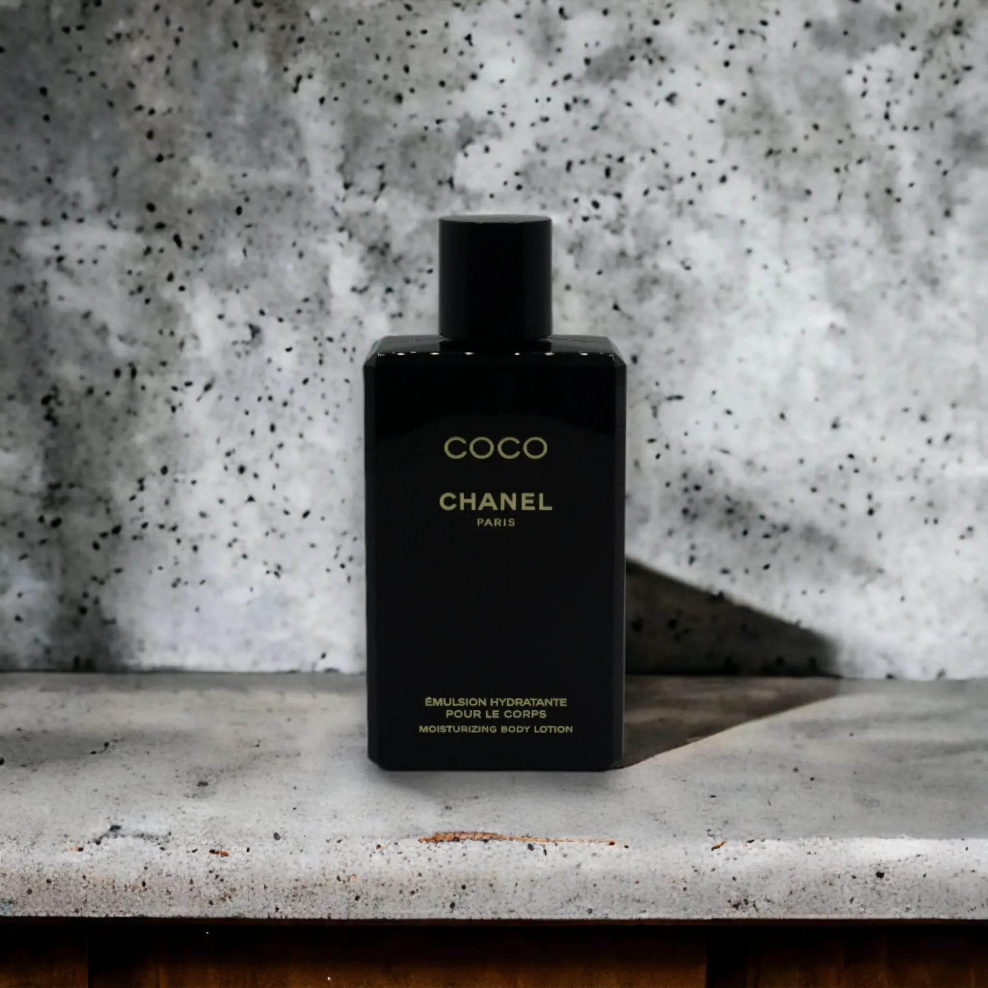 Schwarze COCO Bodylotion-Flasche, minimalistisch gestaltet, auf Marmoroberfläche stehend
