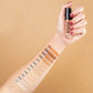 Arm mit verschiedenen Concealer-Farbnuancen geswatcht, Hand hält Pro Light Concealer.