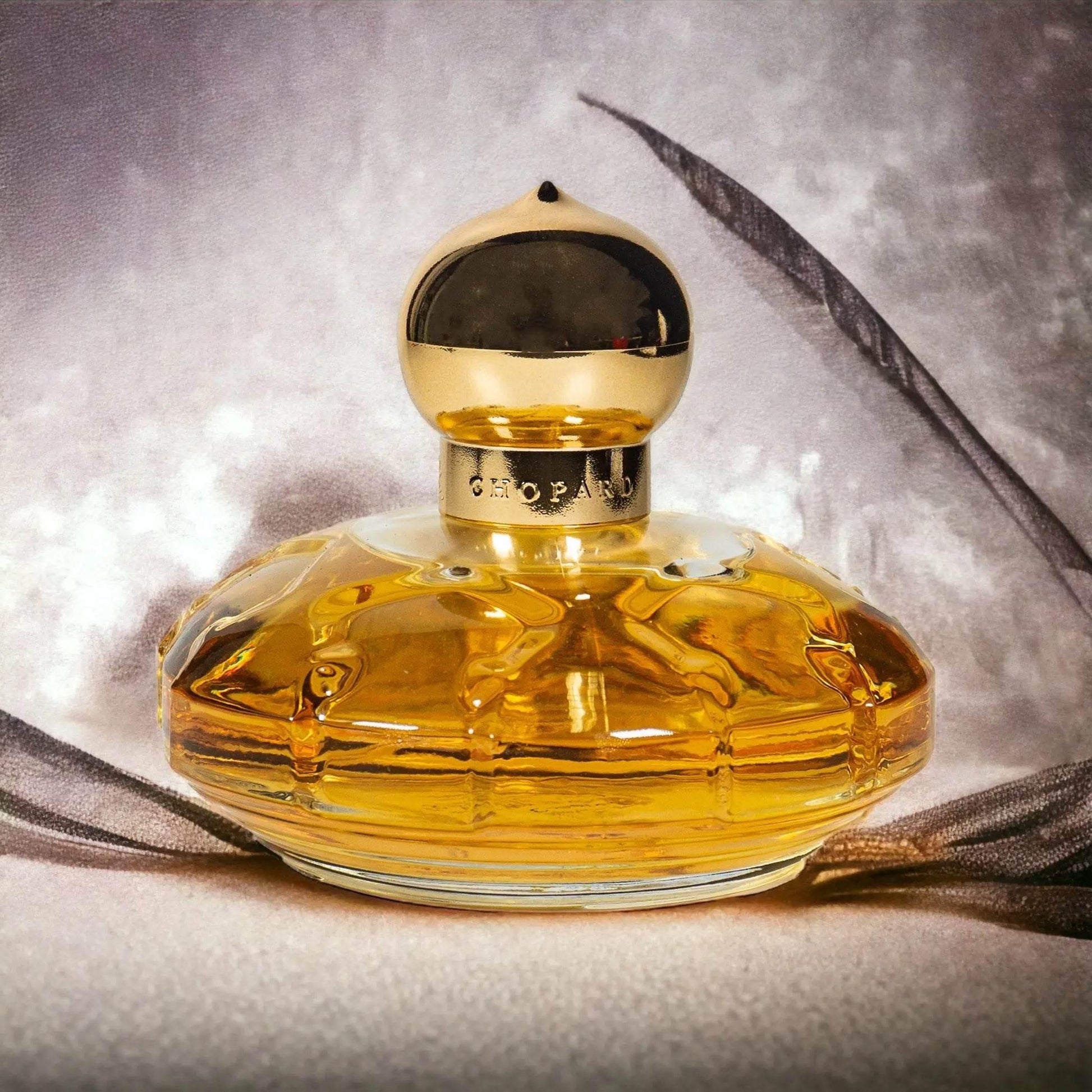 Luxuriöser Casmir Eau de Parfum Flakon mit goldener Kappe vor elegantem Hintergrund