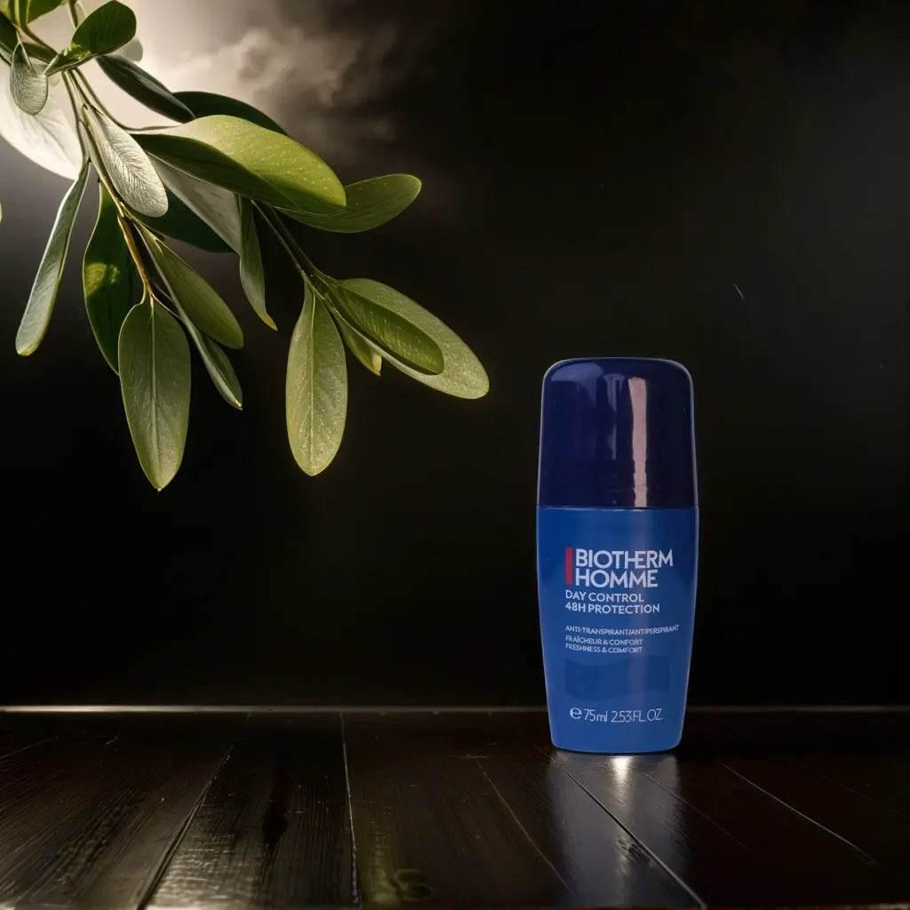 Blauer Deo-Stick für Männer auf dunklem Holztisch, dekoriert mit grünem Zweig, Biotherm Homme Day Control 48H Protection, Kosmetikprodukt.