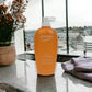 Orange Biotherm EAU D'Énergie Bodylotion auf Marmor mit Blumen und Handtuch, Tageslicht