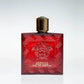 Roter Parfumflakon mit goldener Kappe, Medusakopf und Aufschrift "Eros Flame Eau de Parfum"