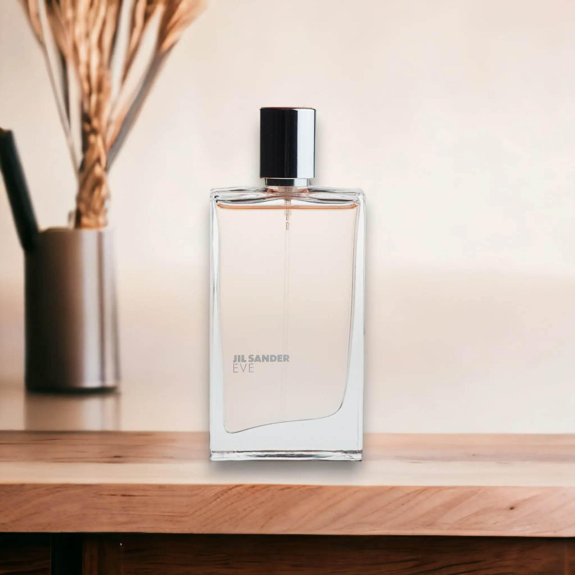 Jil Sander Eve Eau de Toilette Flakon auf Holzoberfläche, minimalistisches Parfumfoto