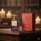Luxusparfum Flakon The Secret Garden Eau de Parfum mit verzierten Verpackung auf Holztisch, umgeben von Kerzen.