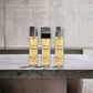 Drei Chanel Gabrielle Eau de Parfum Flakons mit silbernem Deckel auf Steinplatte
