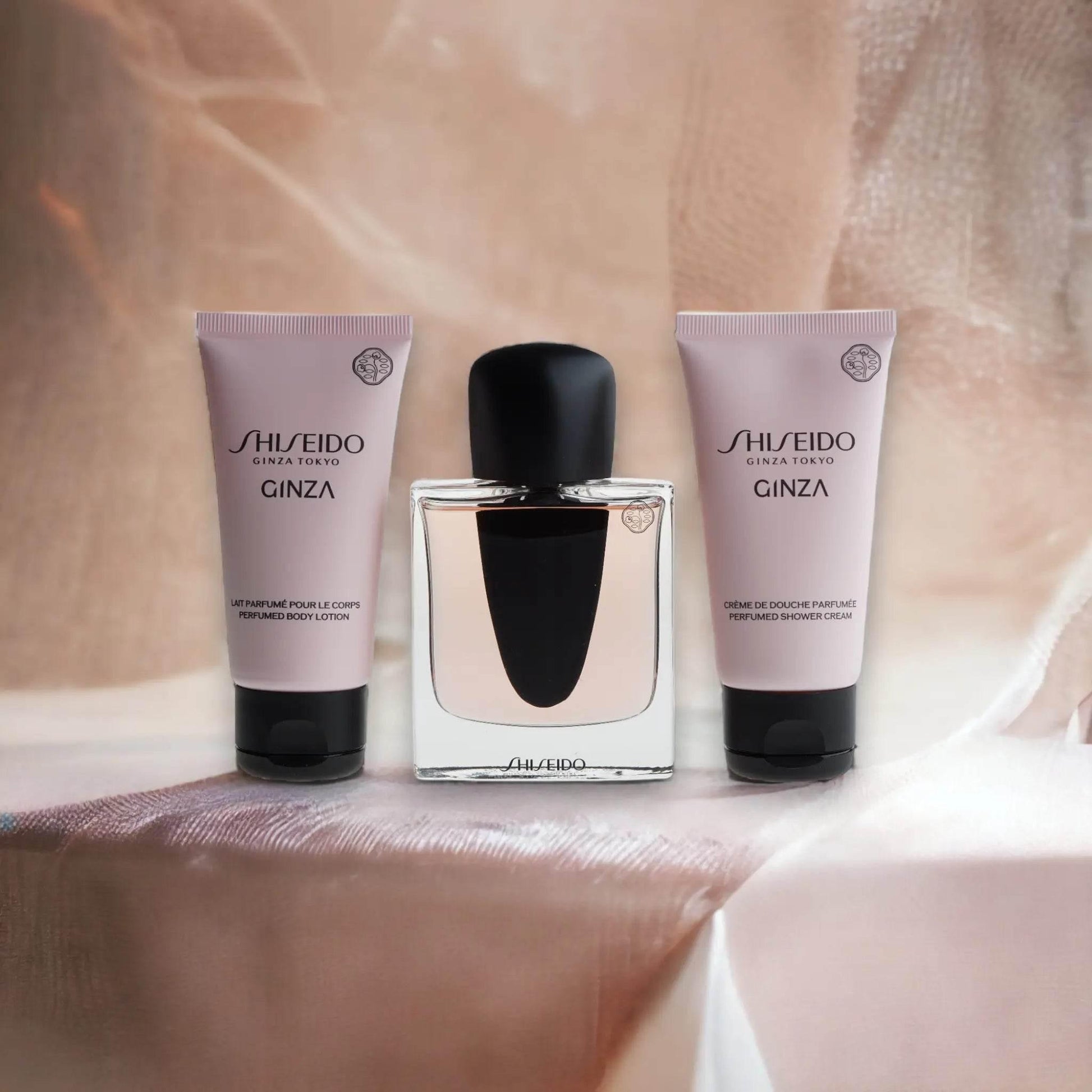 Shiseido Ginza Duftset mit Eau de Parfum, Duschcreme und Bodylotion auf beigem Stoff