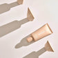 Beigefarbene Tube Mesaudaskin Hydraware Fluid SPF 50 Feuchtigkeitscreme auf hellem Hintergrund
