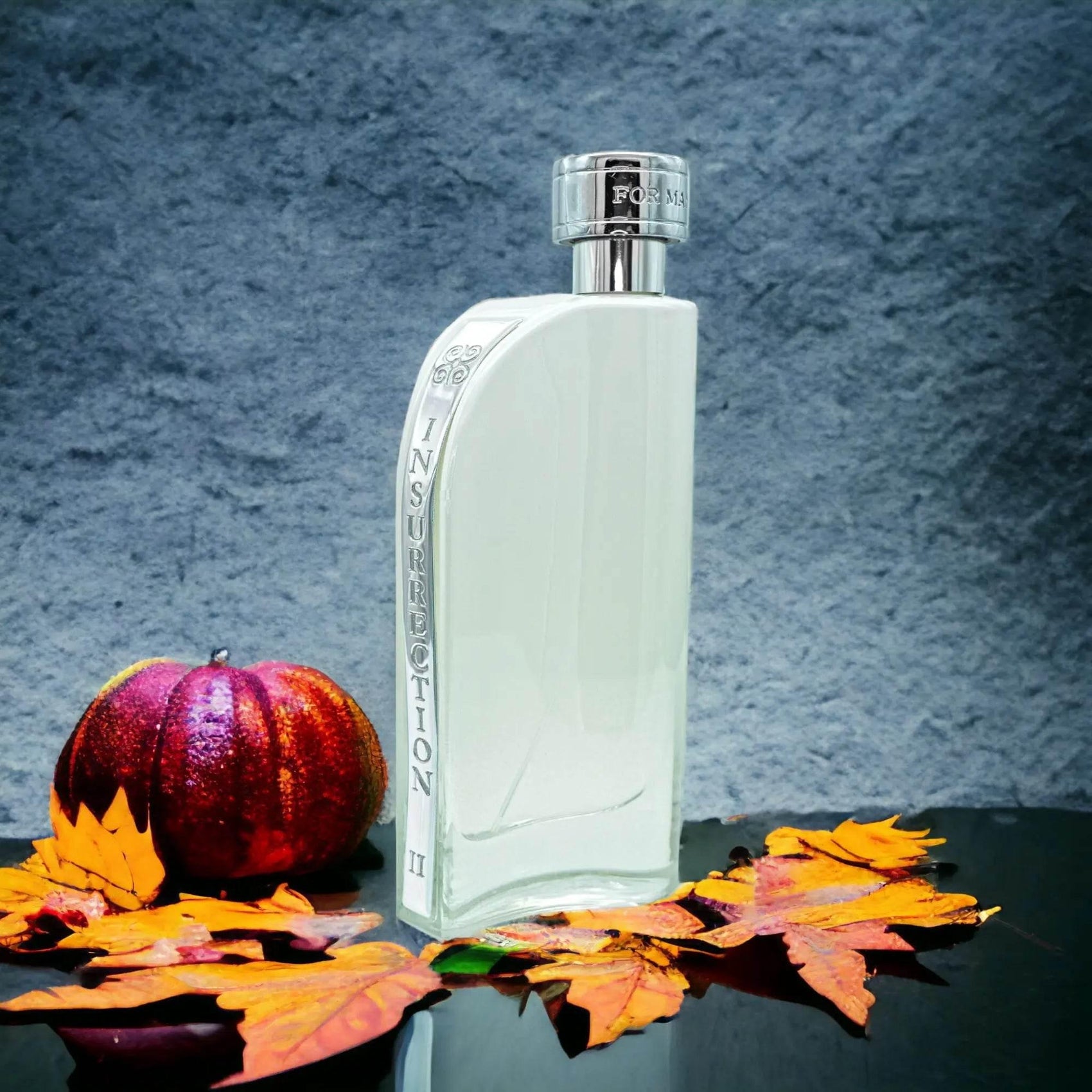 Klares Eau de Toilette Parfumflakon Insurrection II mit silbernem Verschluss, dekoriert mit Herbstblättern und Kürbis