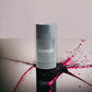 Invictus Deodorant Stick vor hellem Hintergrund, Glasboden mit pinken und schwarzen Farbspritzern