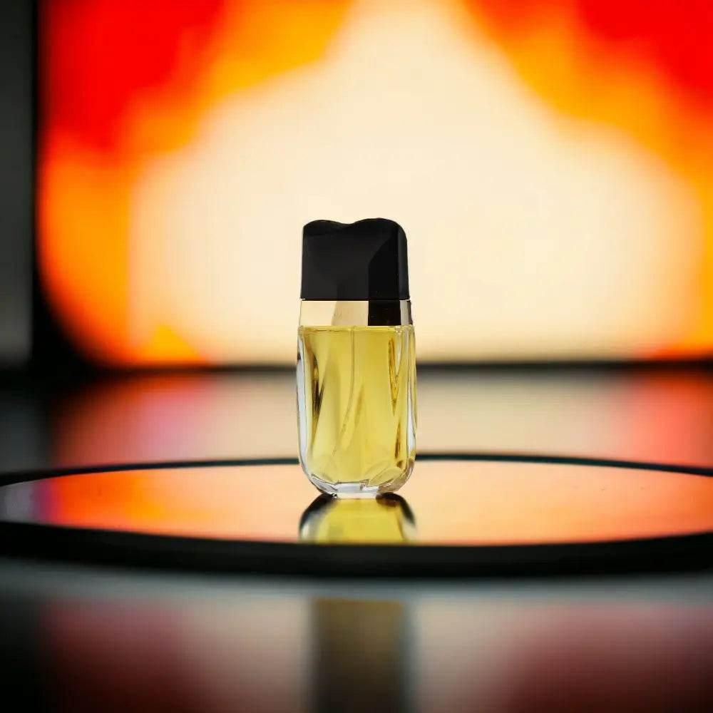 Luxuriöser Parfumflakon mit gelber Flüssigkeit vor warmem, verschwommenem Hintergrund