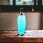 Blauer Biotherm L'Eau Eau de Toilette Flakon auf Holztisch, luxuriöses Parfümprodukt