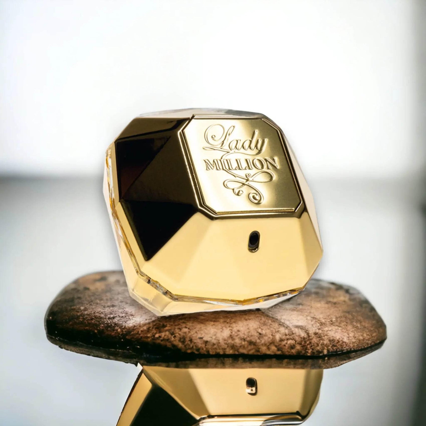 Luxuriöses Lady Million Parfüm in goldener Diamantflakon auf Stein, Nahaufnahme