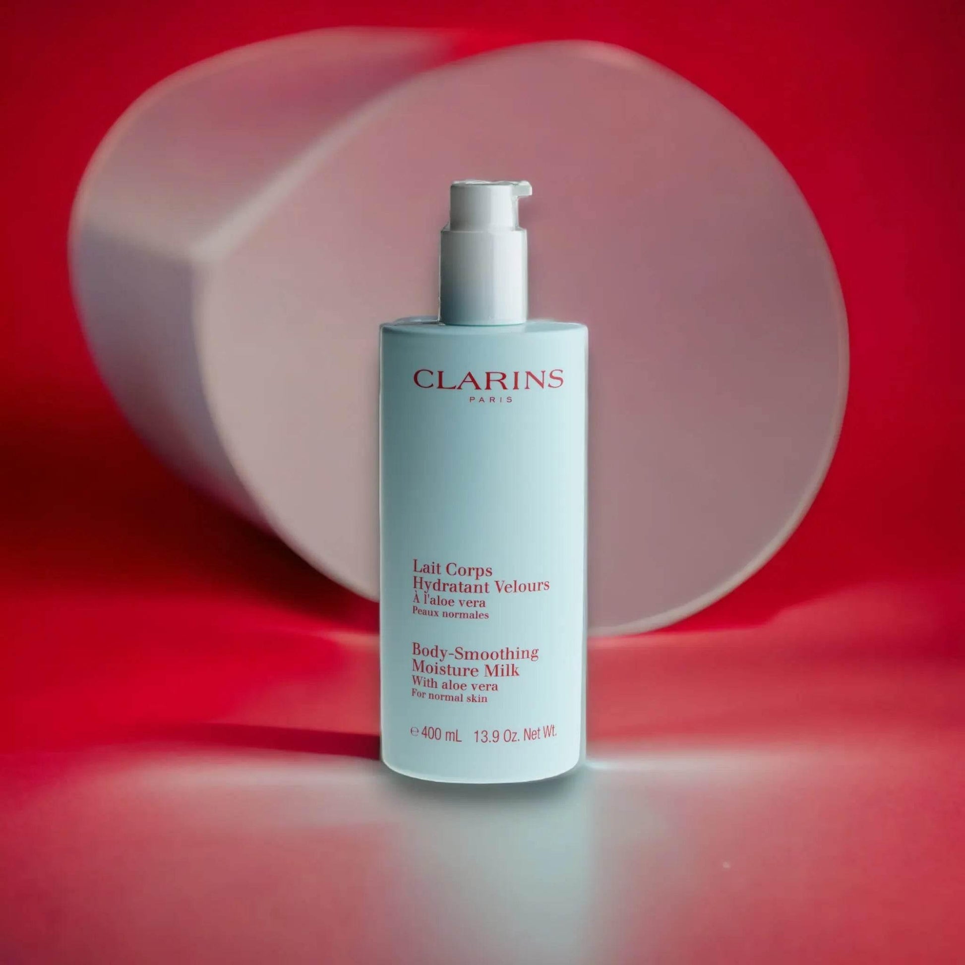 Clarins Bodylotion Lait Corps Hydratant Velours mit Aloe Vera, 400ml, auf rotem Hintergrund