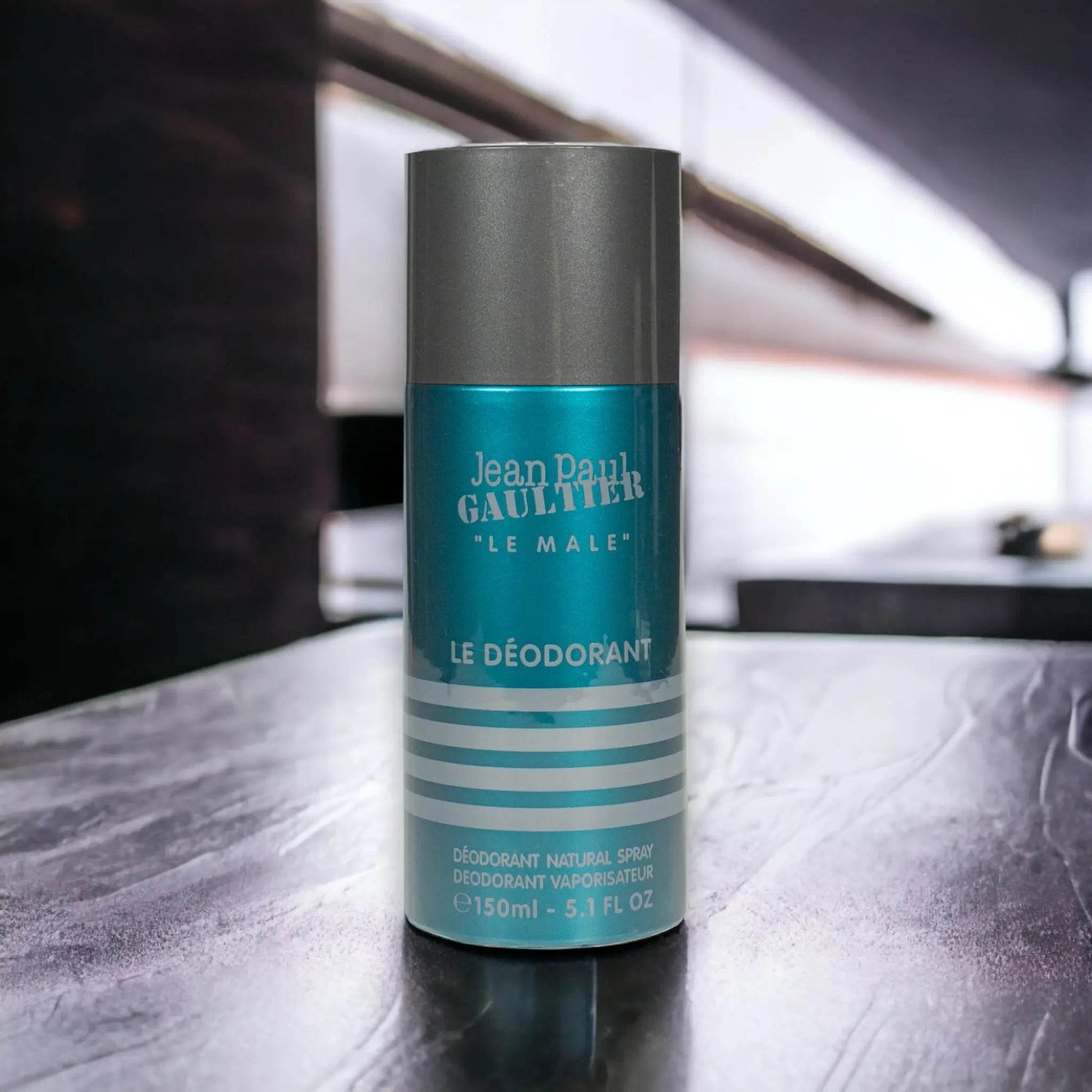 Blauer Le Male Deodorant Spray 150ml auf modernem, glänzendem Tisch, Männerpflege Produkt