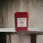 Rote Duftkerze Tom Ford Lost Cherry auf steinernem Hintergrund, Luxuswohnaccessoire