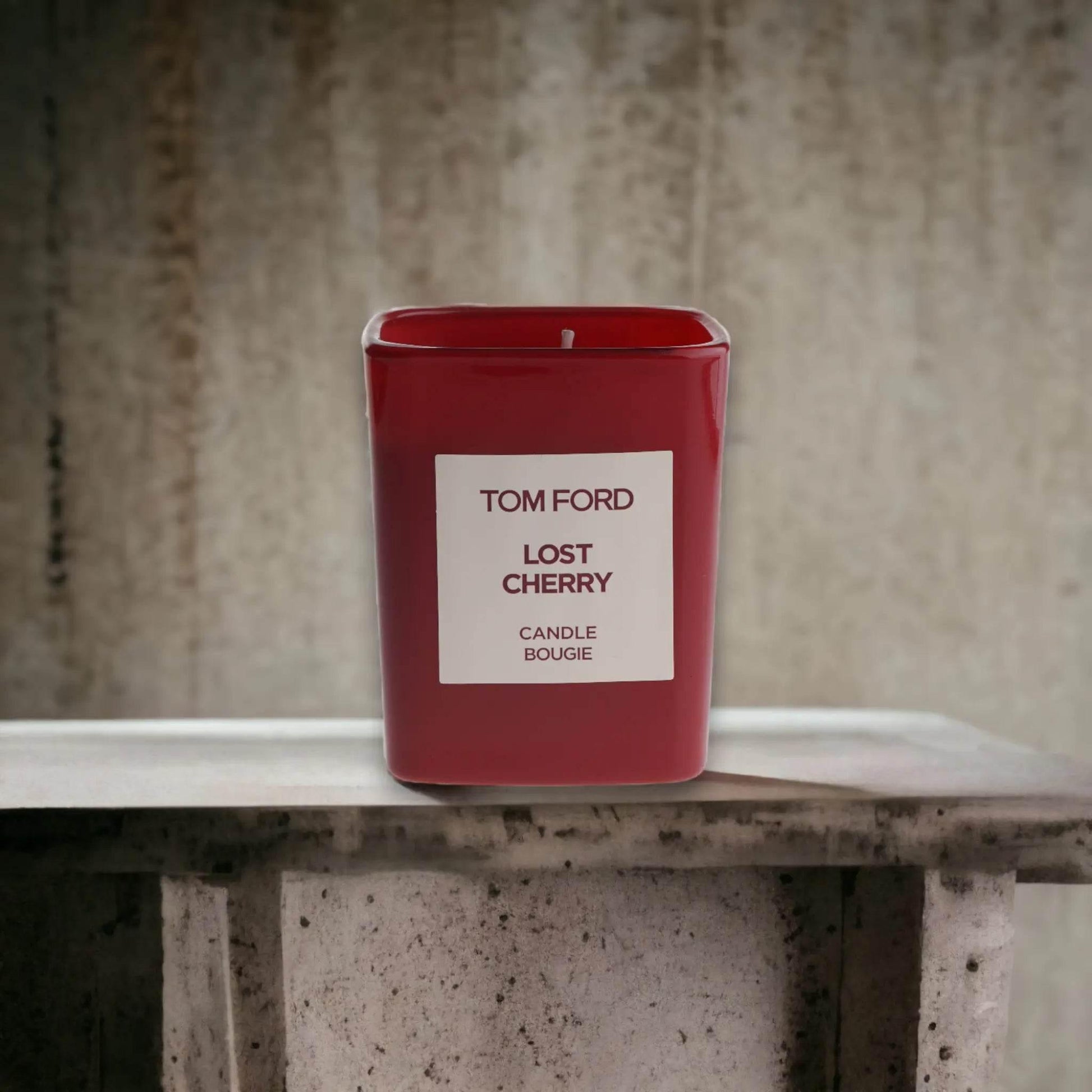 Rote Duftkerze Tom Ford Lost Cherry auf steinernem Hintergrund, Luxuswohnaccessoire