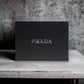 Schwarze Luxus Parfum Geschenkbox mit silbernem PRADA Schriftzug, elegant auf Tisch