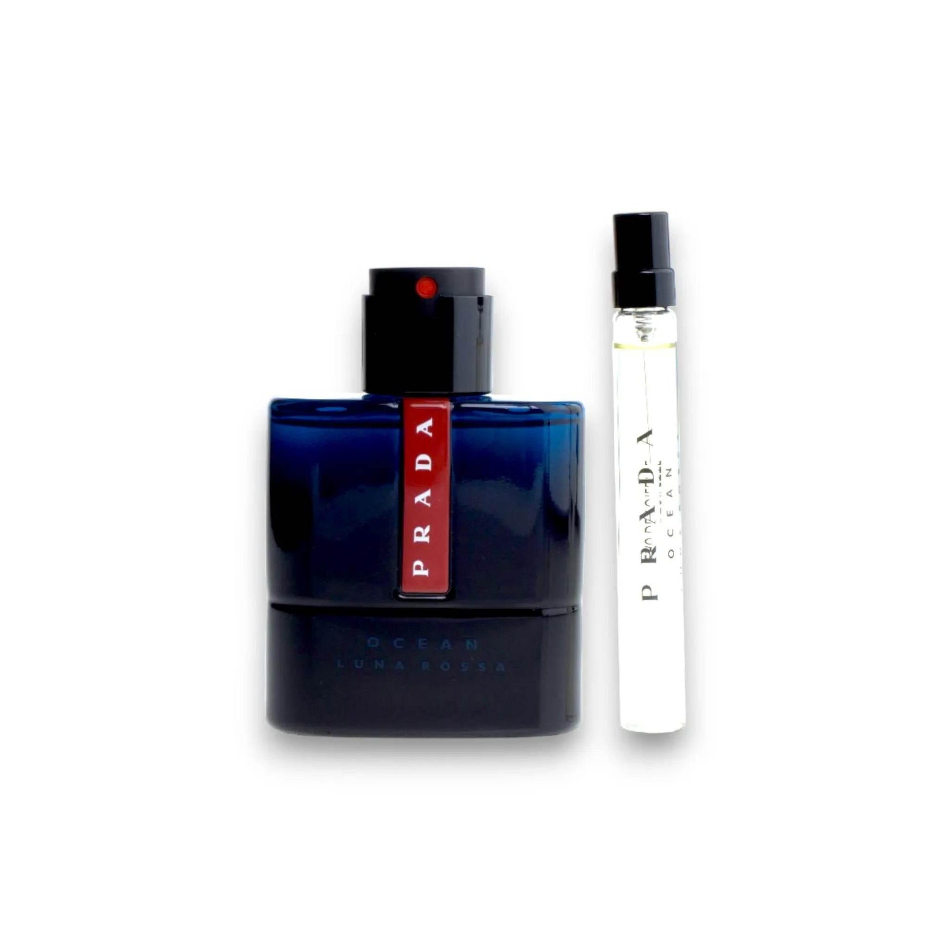 Zwei Designerparfums, ein dunkler Flakon und ein Reisespray mit PRADA Logo, auf weißem Hintergrund.