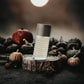 Herren Eau de Toilette Flakon auf Baumstumpf, umgeben von kleinen Kürbissen, herbstliche Stimmung