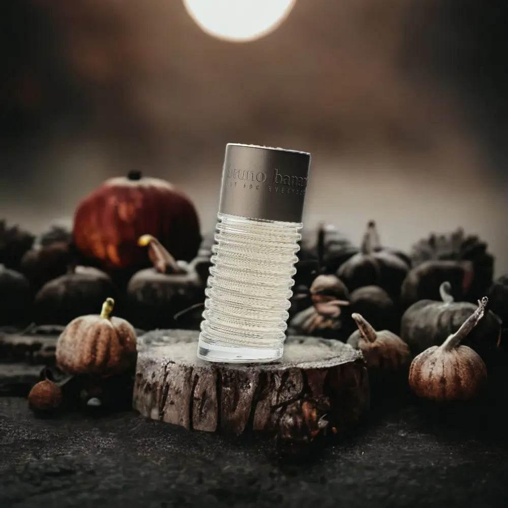 Herren Eau de Toilette Flakon auf Baumstumpf, umgeben von kleinen Kürbissen, herbstliche Stimmung