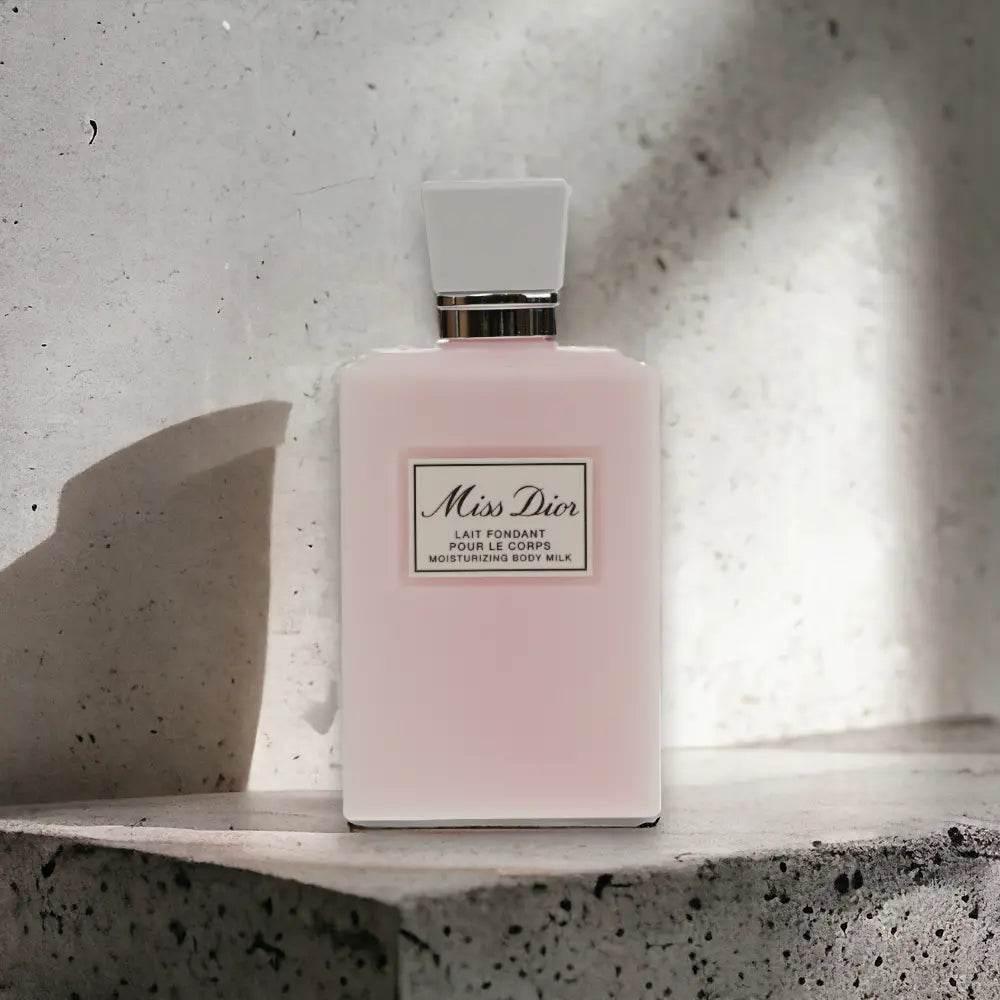 Miss Dior Body Milk Flakon, rosa Körperlotion auf heller Steinfläche, luxuriöse Kosmetik