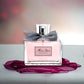 Miss Dior Eau de Parfum Flakon mit rosa Duft, Schleife und stilvollem Hintergrund