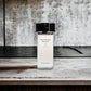 Modern Muse Eau de Parfum Flakon auf Marmor, luxuriöses Parfum, minimalistisches Design