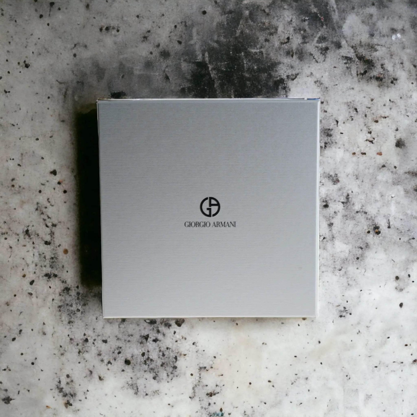 Graue Geschenkbox mit Giorgio Armani Logo auf marmoriertem Untergrund, Duftset Verpackung