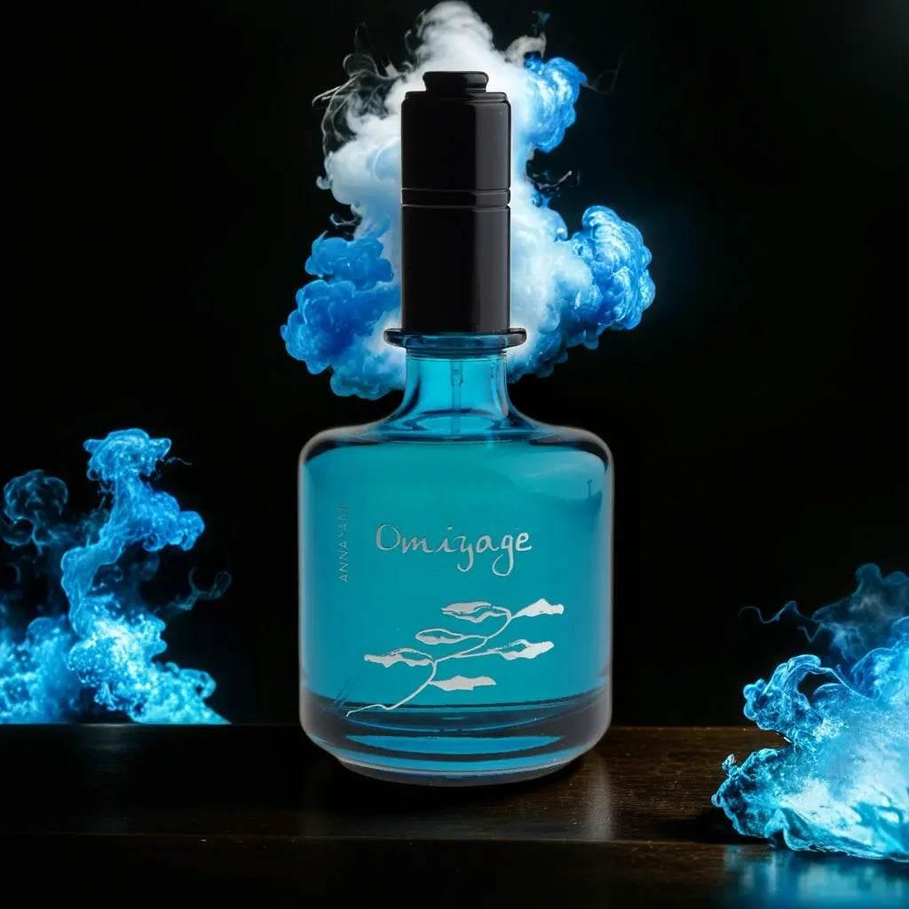 Blauer Omiyage Eau de Toilette Flakon für Herren mit schwarzem Sprühkopf, umgeben von blauem Rauch vor dunklem Hintergrund