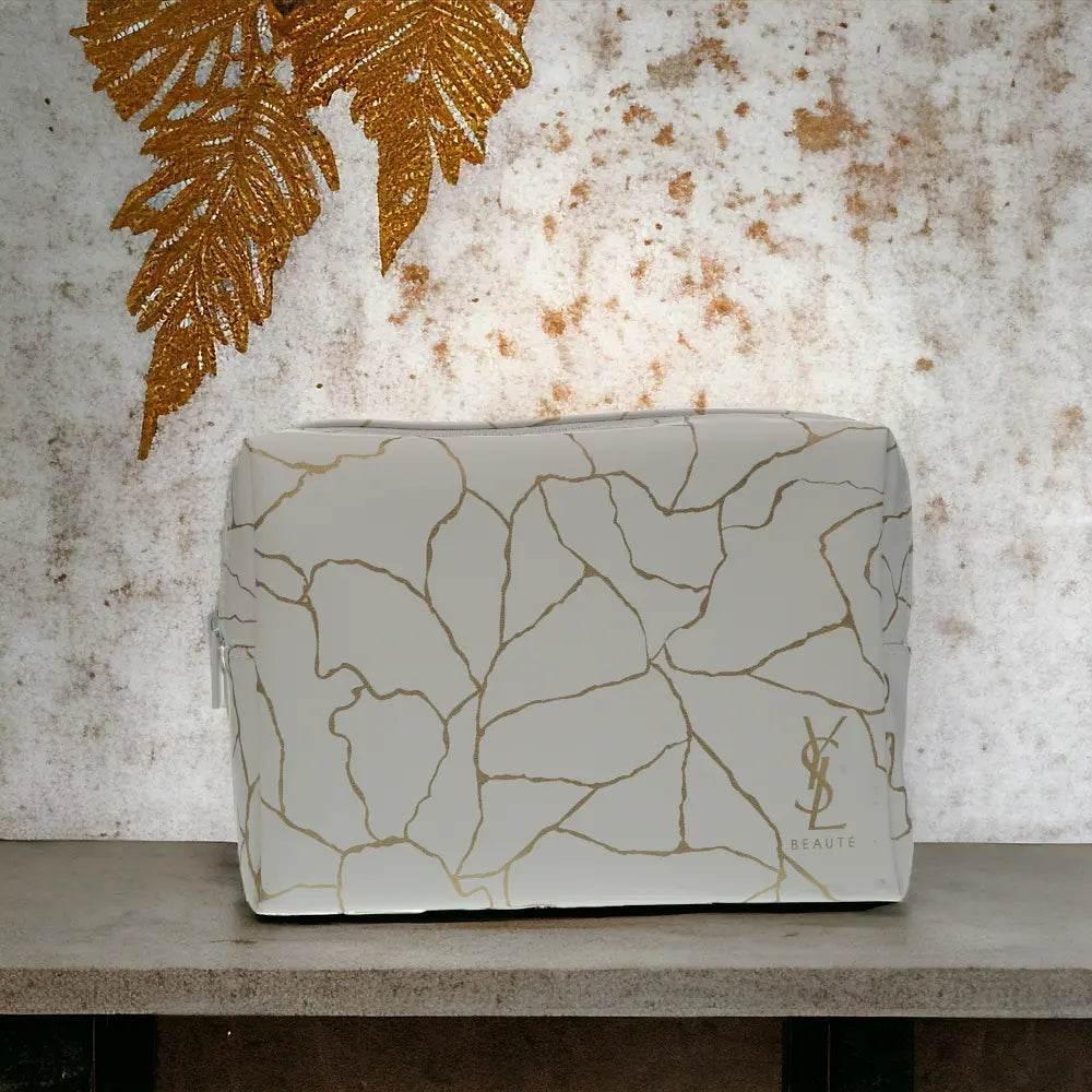 Luxuriöses Parfum-Set in weiß-goldener Box mit Blattmuster auf neutralem Hintergrund