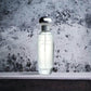 Eleganter Parfumflakon mit silbernem Verschluss vor marmoriertem Hintergrund