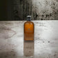 Molton Brown Re-Charge Black Pepper Duschgel Flasche auf Betonoberfläche, luxuriöse Körperpflege