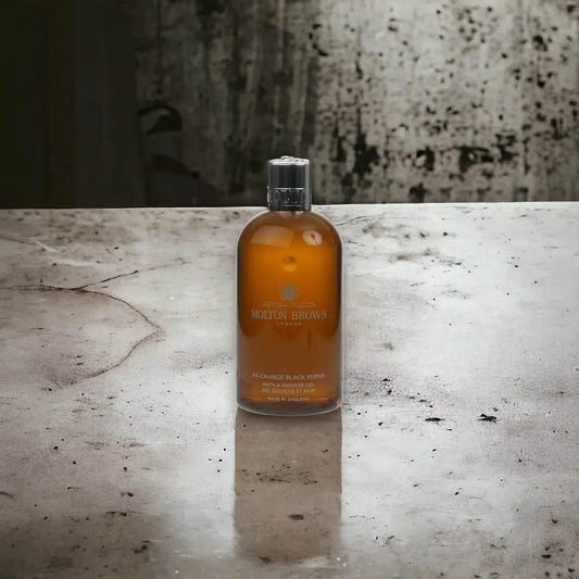 Molton Brown Re-Charge Black Pepper Duschgel Flasche auf Betonoberfläche, luxuriöse Körperpflege