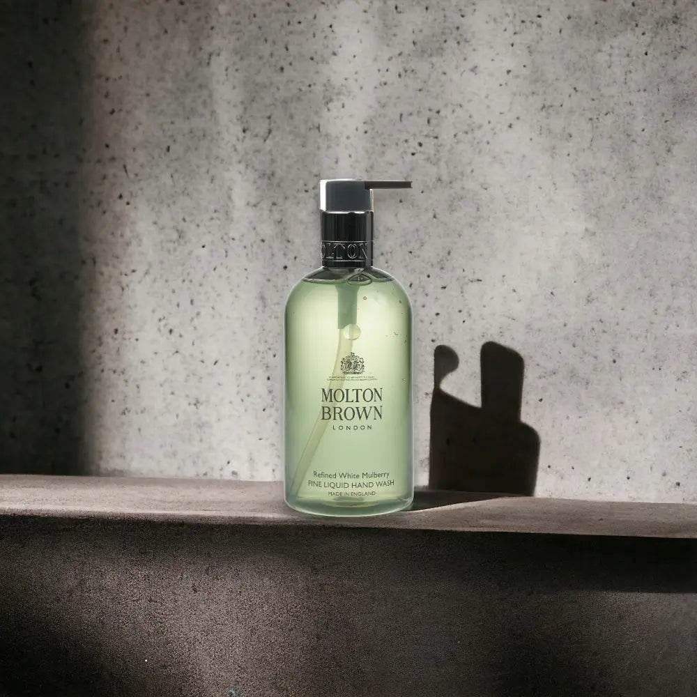 Molton Brown Refined White Mulberry Handseife, edle Flüssigseife mit Pumpspender vor Betonwand