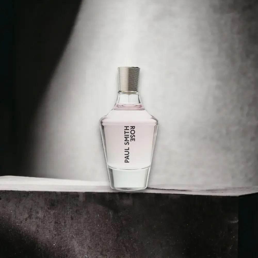 Elegantes Parfumflakon mit rosa Flüssigkeit, Aufschrift „PAUL SMITH ROSE“, minimalistischer Hintergrund.