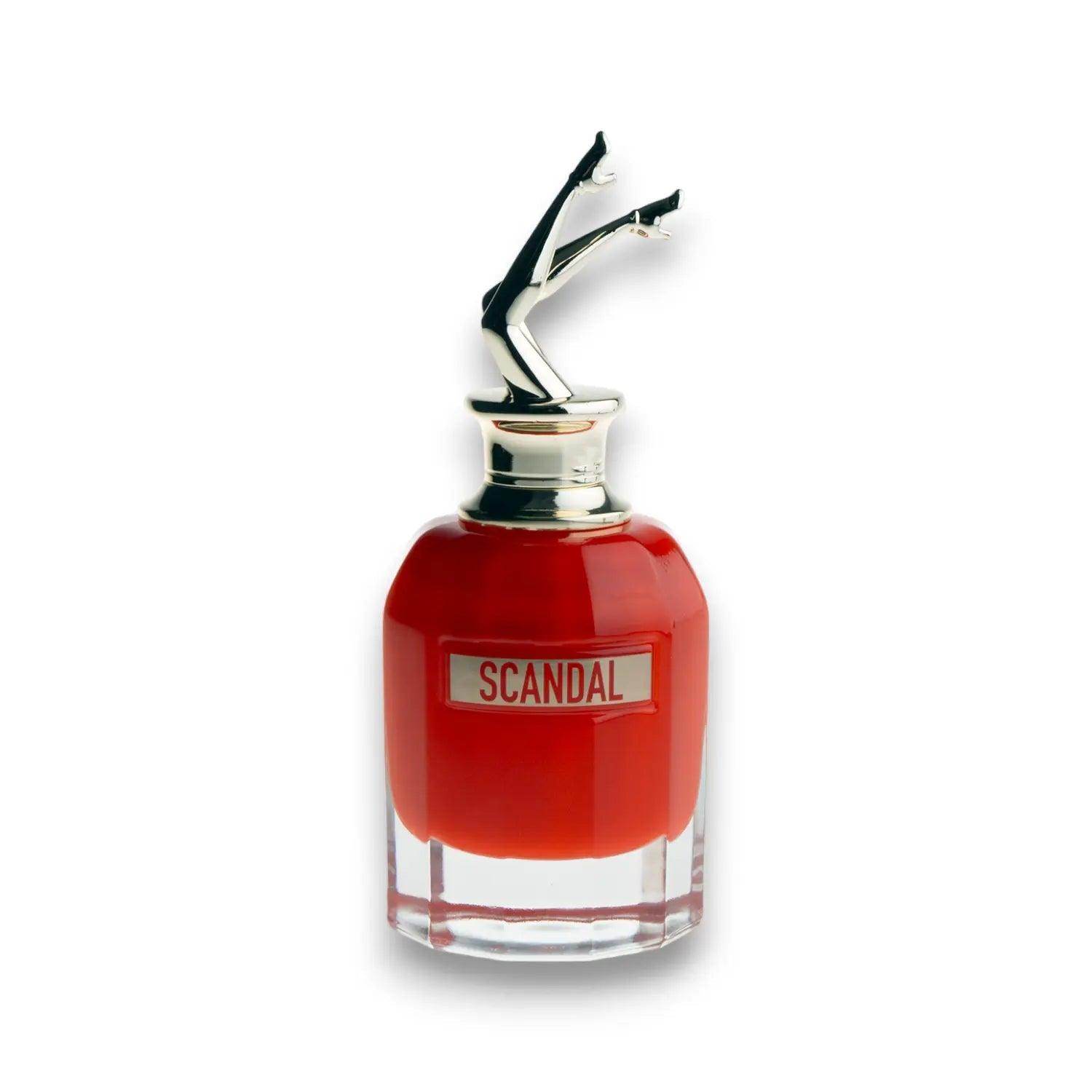 Rotes Parfumflakon mit Schriftzug Scandal und dekorativem Verschluss in Bein-Form auf weißem Hintergrund.