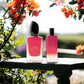Si Passione Duftset Eau de Parfum, rote Parfümflaschen auf Holztisch mit Blumen im Hintergrund