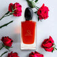 Rotes Si Passione Eau de Parfum Flakon mit schwarzen Verschluss, umgeben von roten Rosen