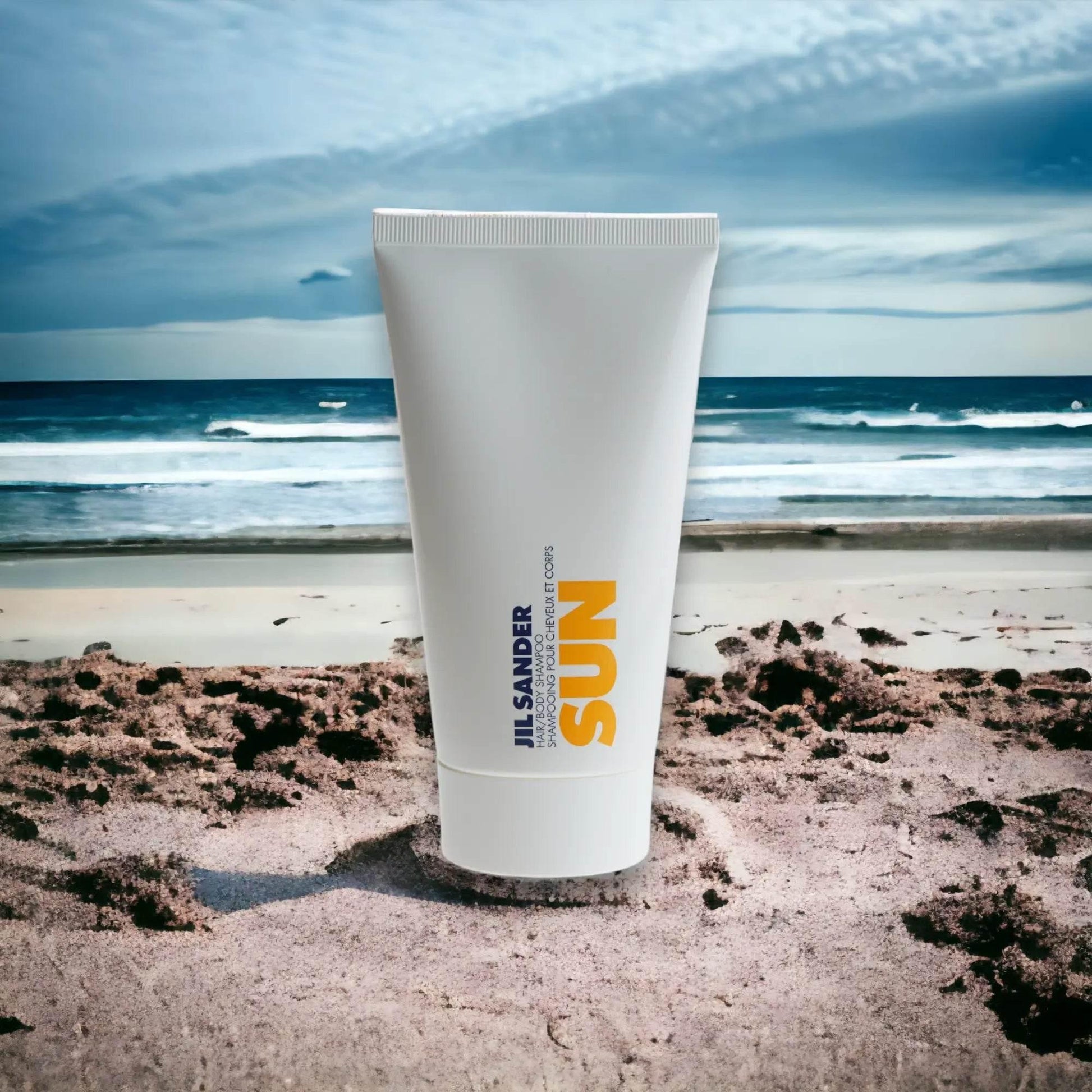 Jil Sander Sun Shampoo für Haar und Körper, weiße Tube am Sandstrand mit Meeresblick