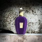 Lila Parfumflakon mit goldener Kappe und Etikett vor marmorierter Wand, luxuriöses Nischenparfum